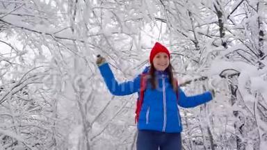 女人在玩-她在摇动树枝，雪落在她身上。 <strong>晴朗晴朗</strong>的霜冻天气
